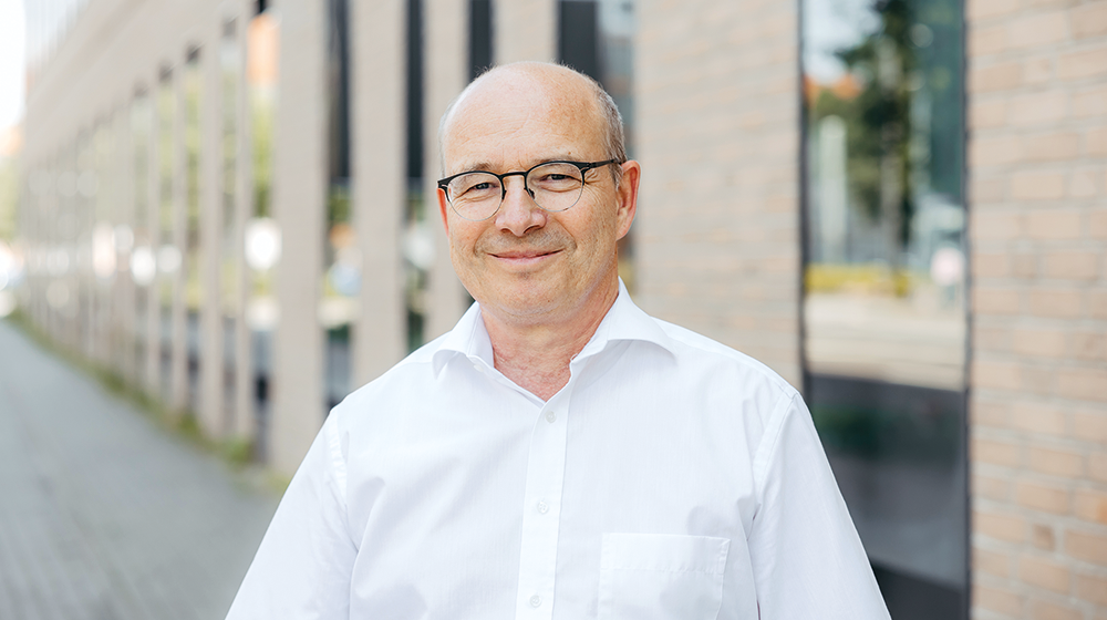 Portrait Prof. Kienle (c) Jana Dünnhaupt Uni Magdeburg Portrait Prof. Kienle vor einem gelben Backsteingebäude auf dem Campus (c) Jana Dünnhaupt Uni Magdeburg