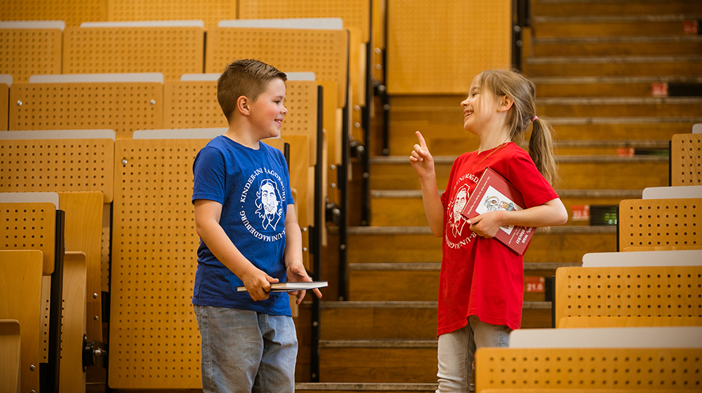 /unimagdeburg_media/Presse/Bilder/Pressemitteilungen/2024/Ein+Junge+und+ein+M%C3%A4dchen+stehen+im+H%C3%B6rsaal+und+warten+auf+die+Kinder_Uni_Vorlesung+%28c%29+Jana+D%C3%BCnnhaupt-height-560-width-1000-p-114676.jpg