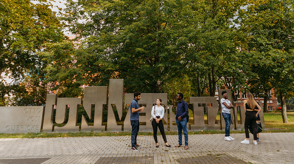 /unimagdeburg_media/Presse/Bilder/Pressemitteilungen/2025/Eine+Gruppe+internationaler+Studierender+steht+vor+dem+Haupteingang+der+Universit%C3%A4t+Magdeburg+mit+dem+Schriftzug+Otto_von_Guericke_Universit%C3%A4t_Foto_Hannah+Theile-height-560-width-1000-p-126731.jpg