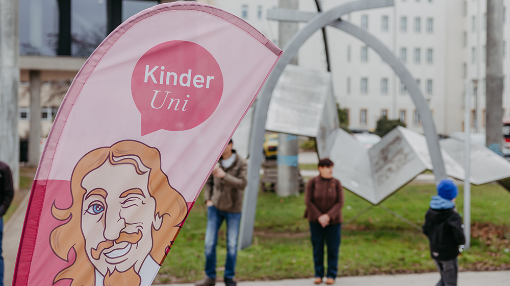 /unimagdeburg_media/Presse/Bilder/Pressemitteilungen/2026/Kinder+Uni+Banner+auf+dem+Campus+%28c%29+Jana+D%C3%BCnnhaupt+Uni+Magdeburg-height-560-width-1000.jpg